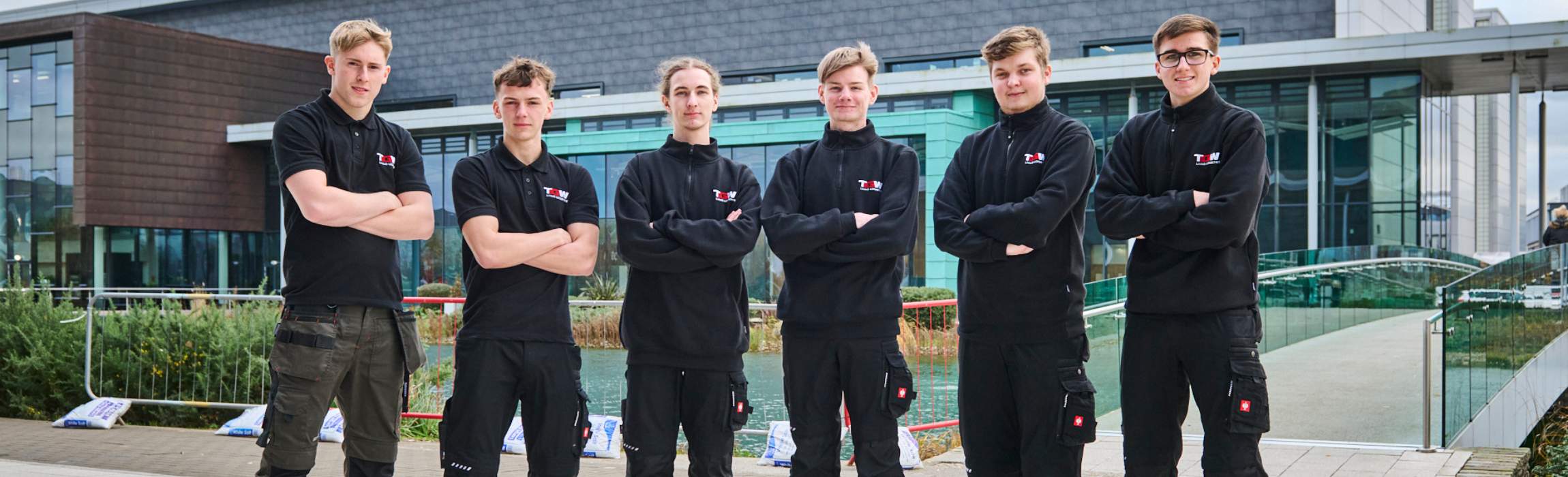 Apprentices and Graduates in front of a building